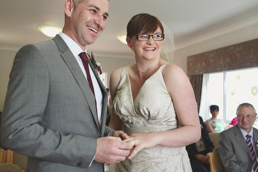 Bride and groom exchanging rings indoors