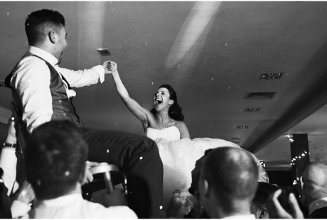 Bride and groom lifted on chairs celebrating
