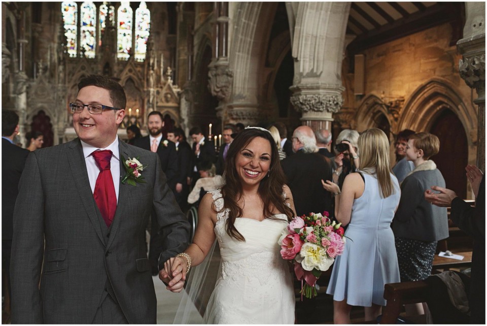 Bride and groom walking down church aisle