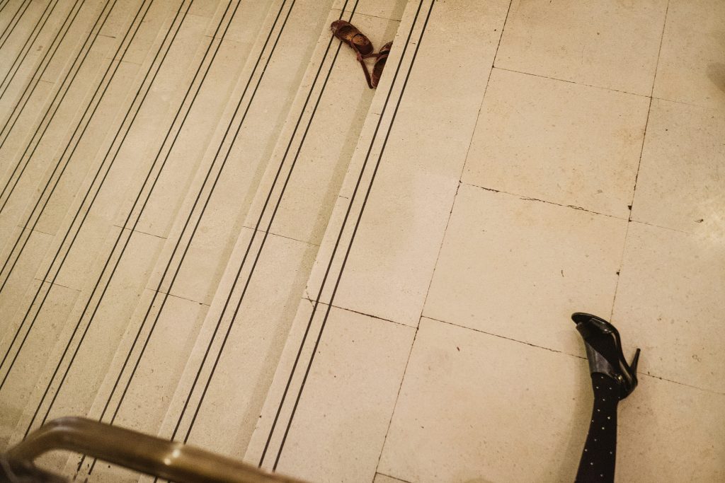 Scattered shoes on tiled staircase during wedding reception, a quiet moment between celebrations.