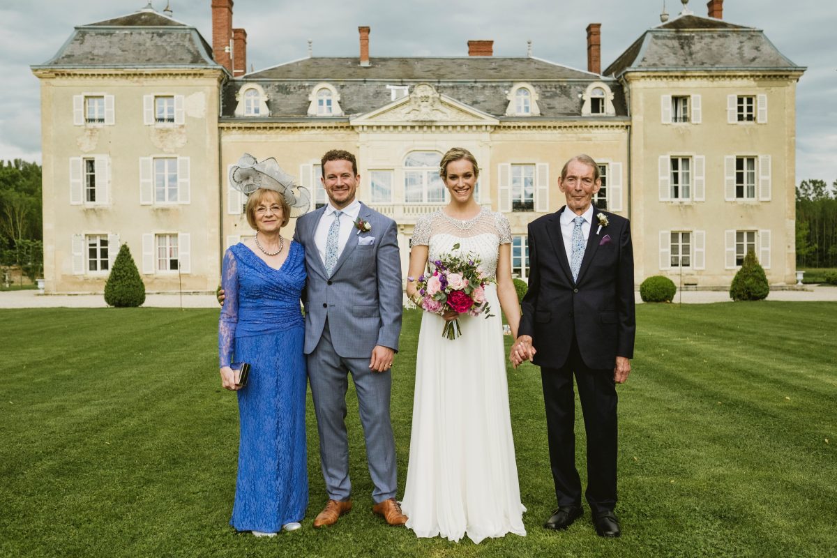 Group wedding photograph at a French Chateau, featuring the Bride, Groom and Mother and Father of the Bride
