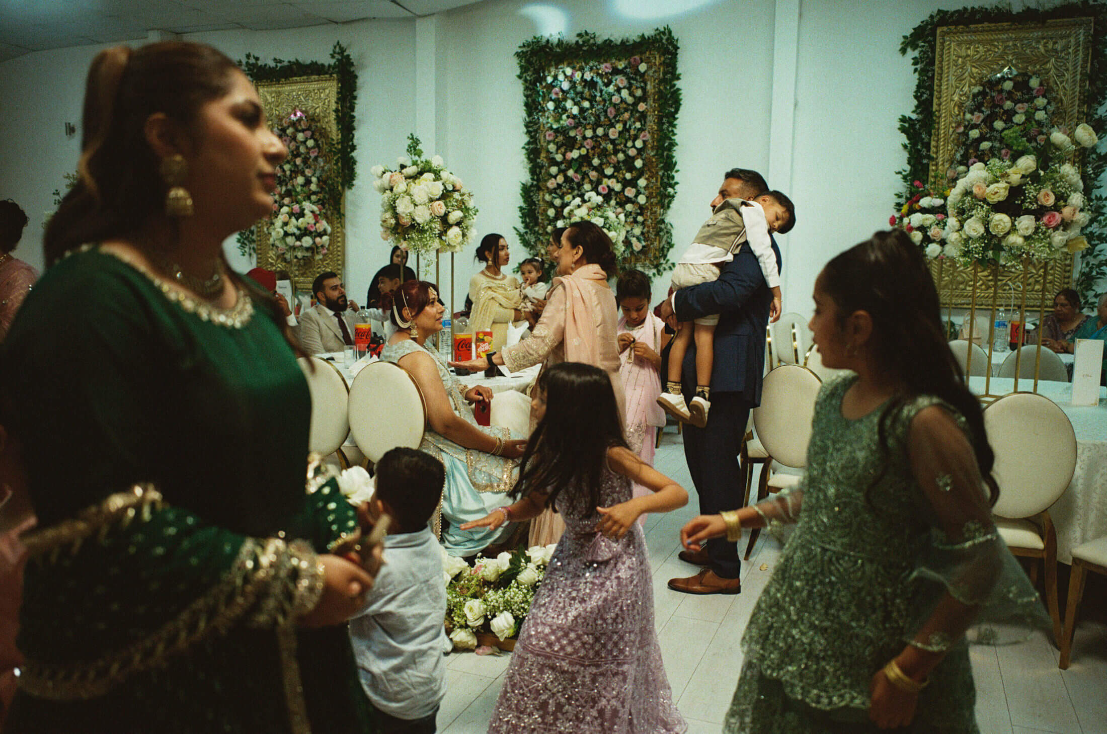 Guests and children moving around a decorated wedding reception room