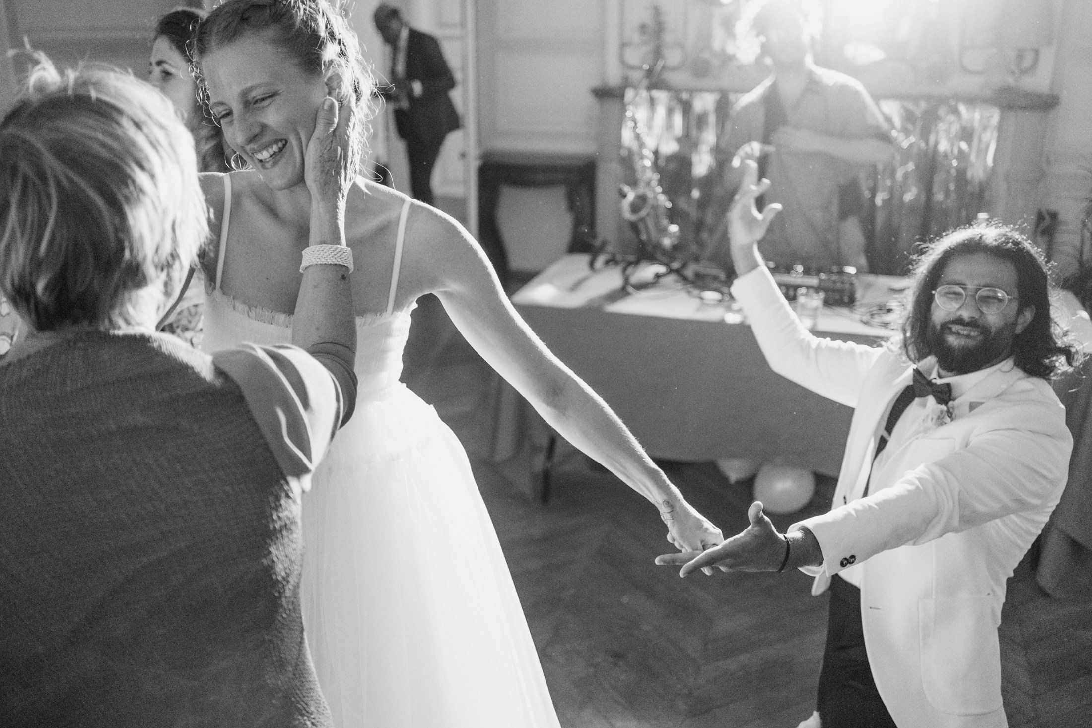 Black and white photo of the bride, sister and best man dancing at Chateau du Fey the Burgundy region of France