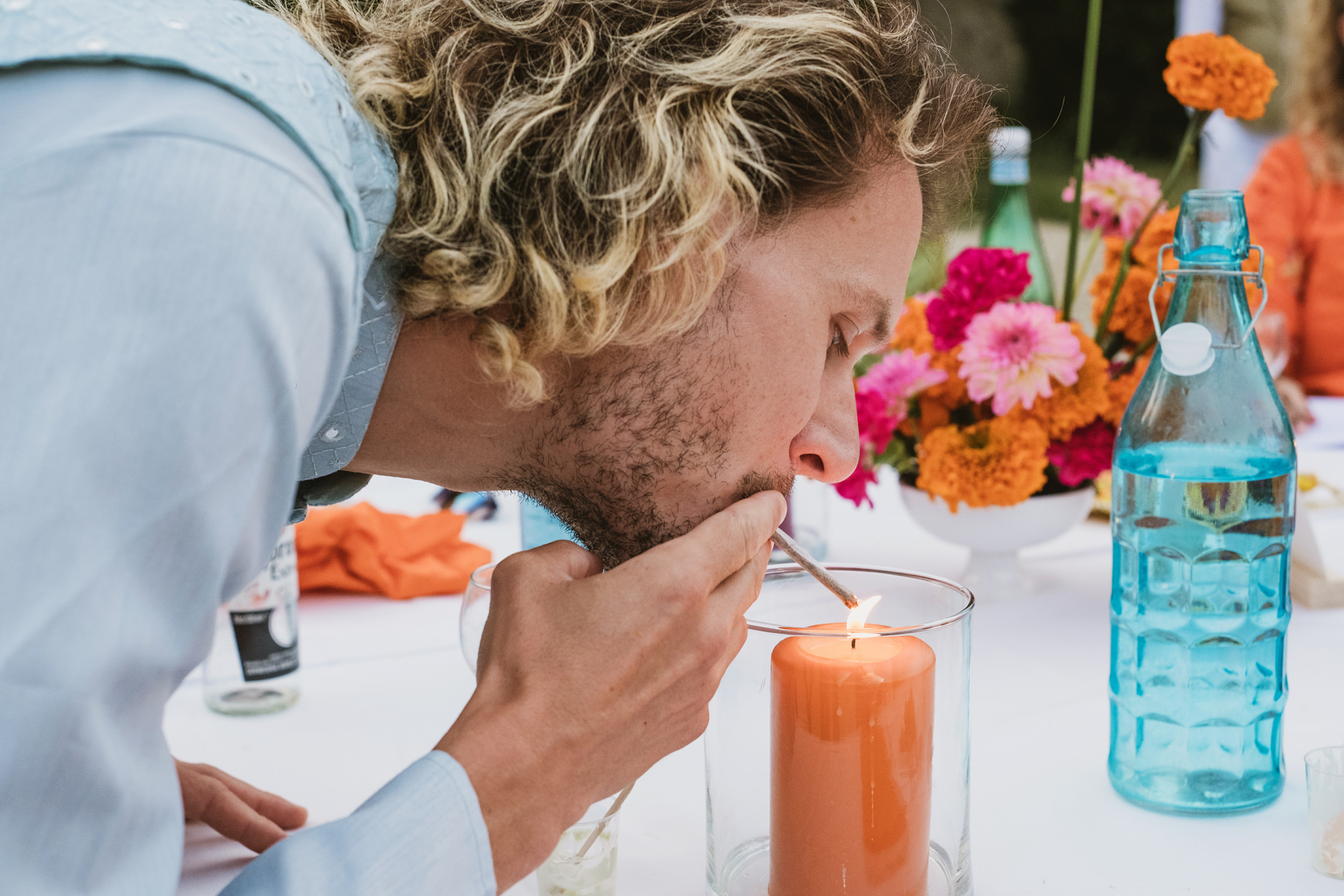 A wedding guest lights his cigarette on a candle at Chateau du Fey in France