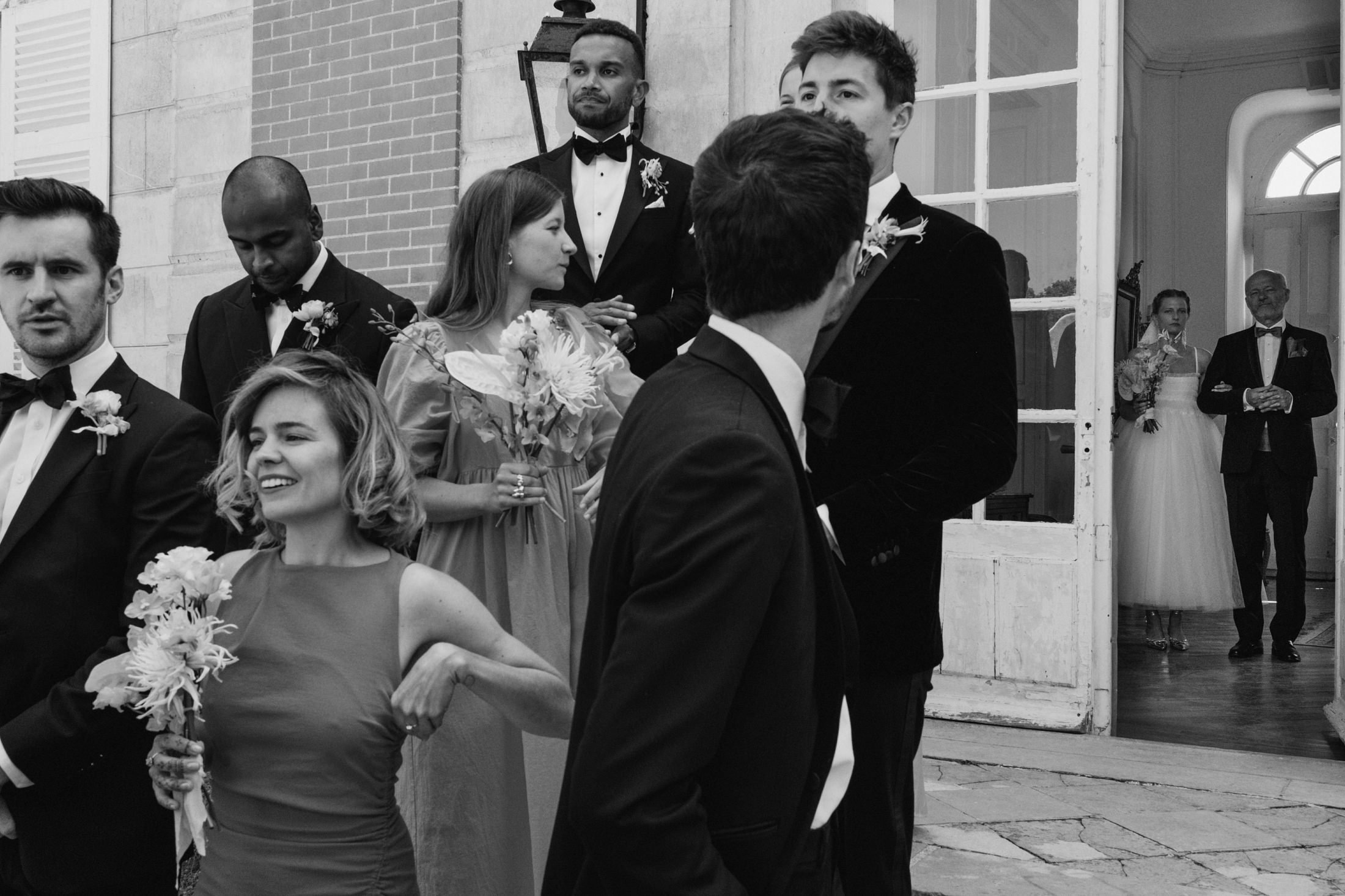 bride nervously waiting for the wedding ceremony to begin. Lined up with the bridal party. Chateau du Fey in France