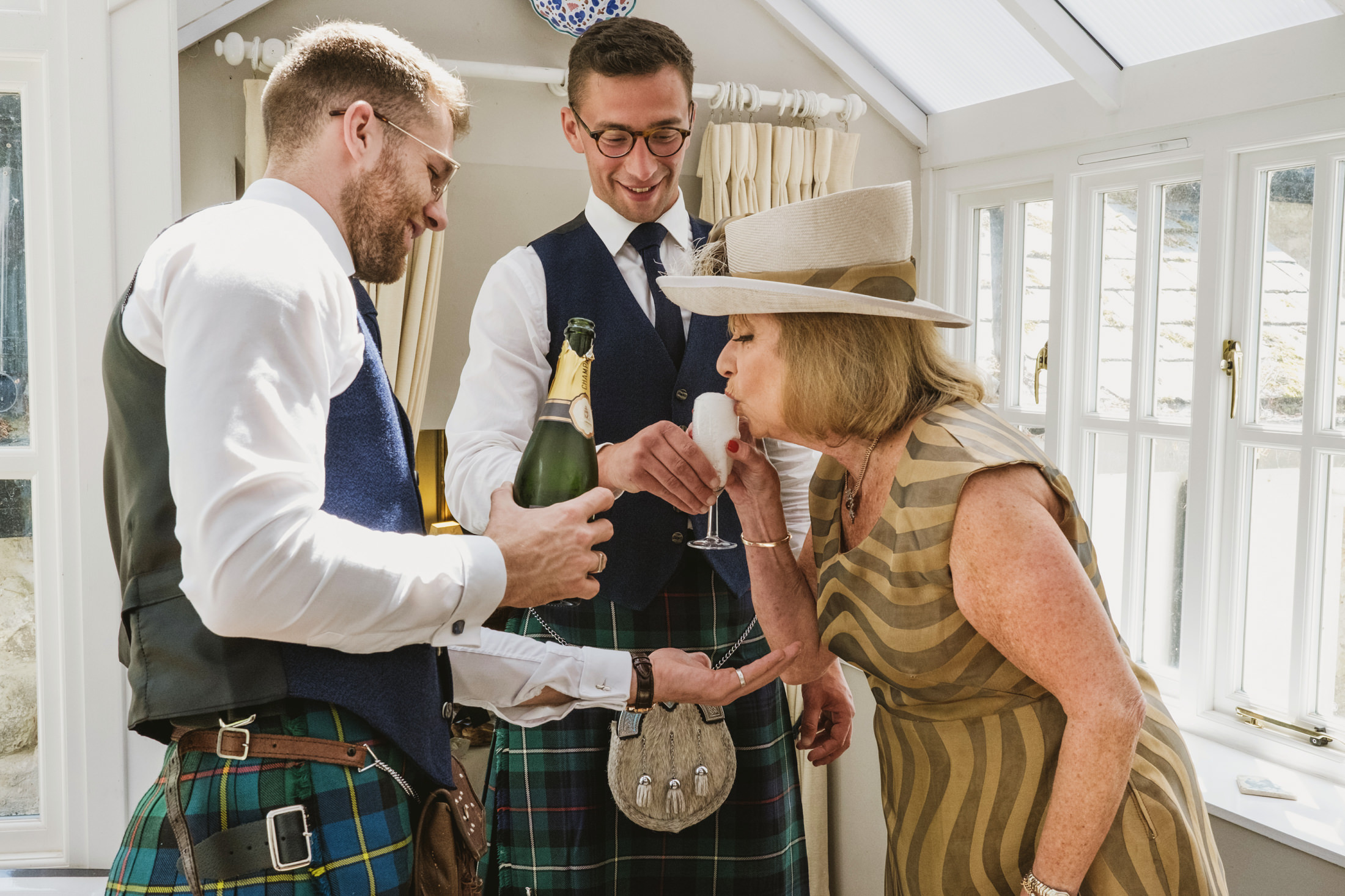 Celebration with champagne and laughter in traditional attire.