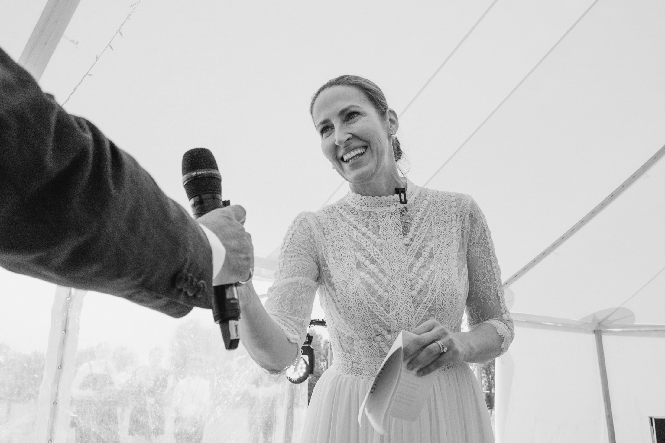 Woman receiving microphone at wedding ceremony.
