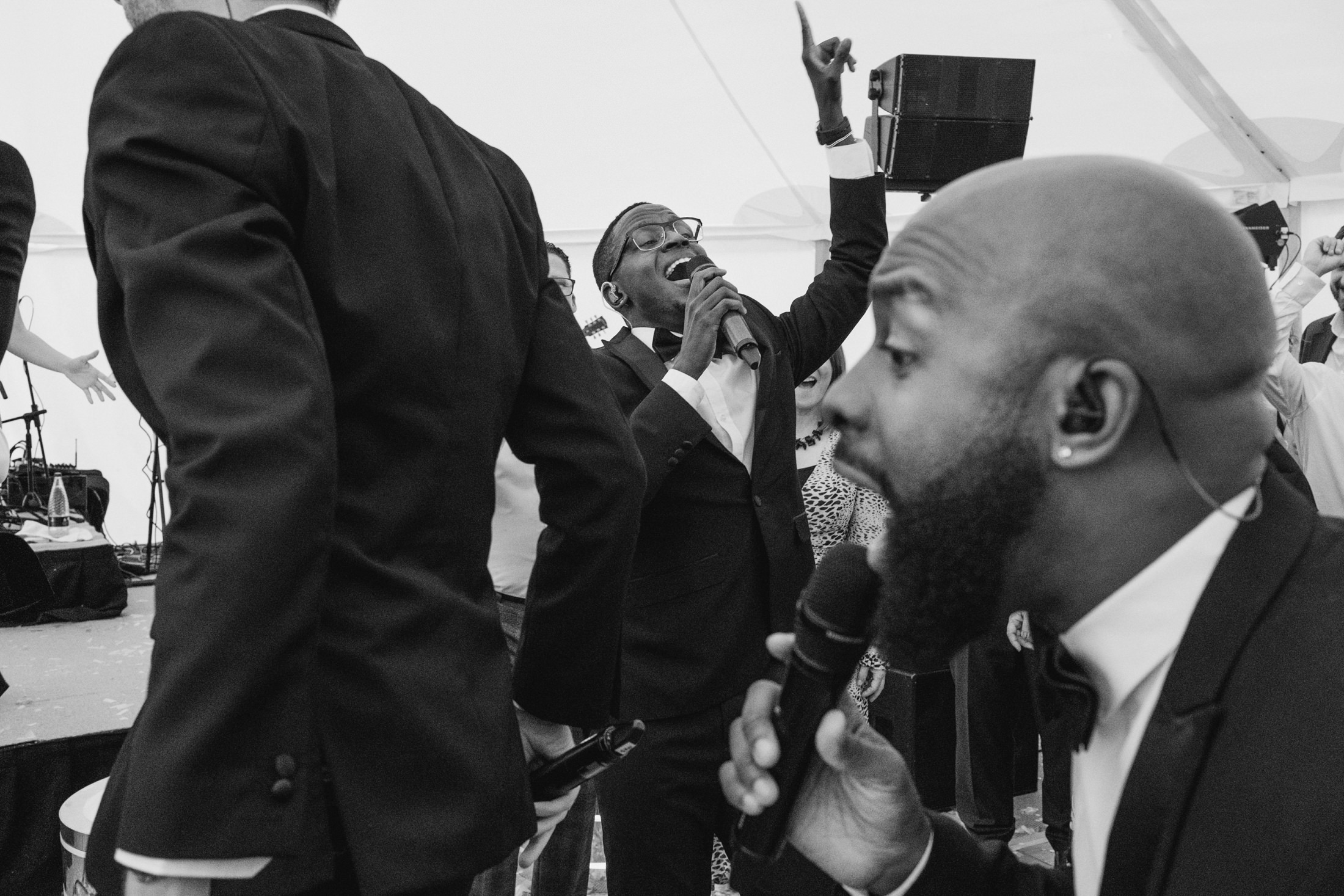 Singers performing energetically with microphones in hands.