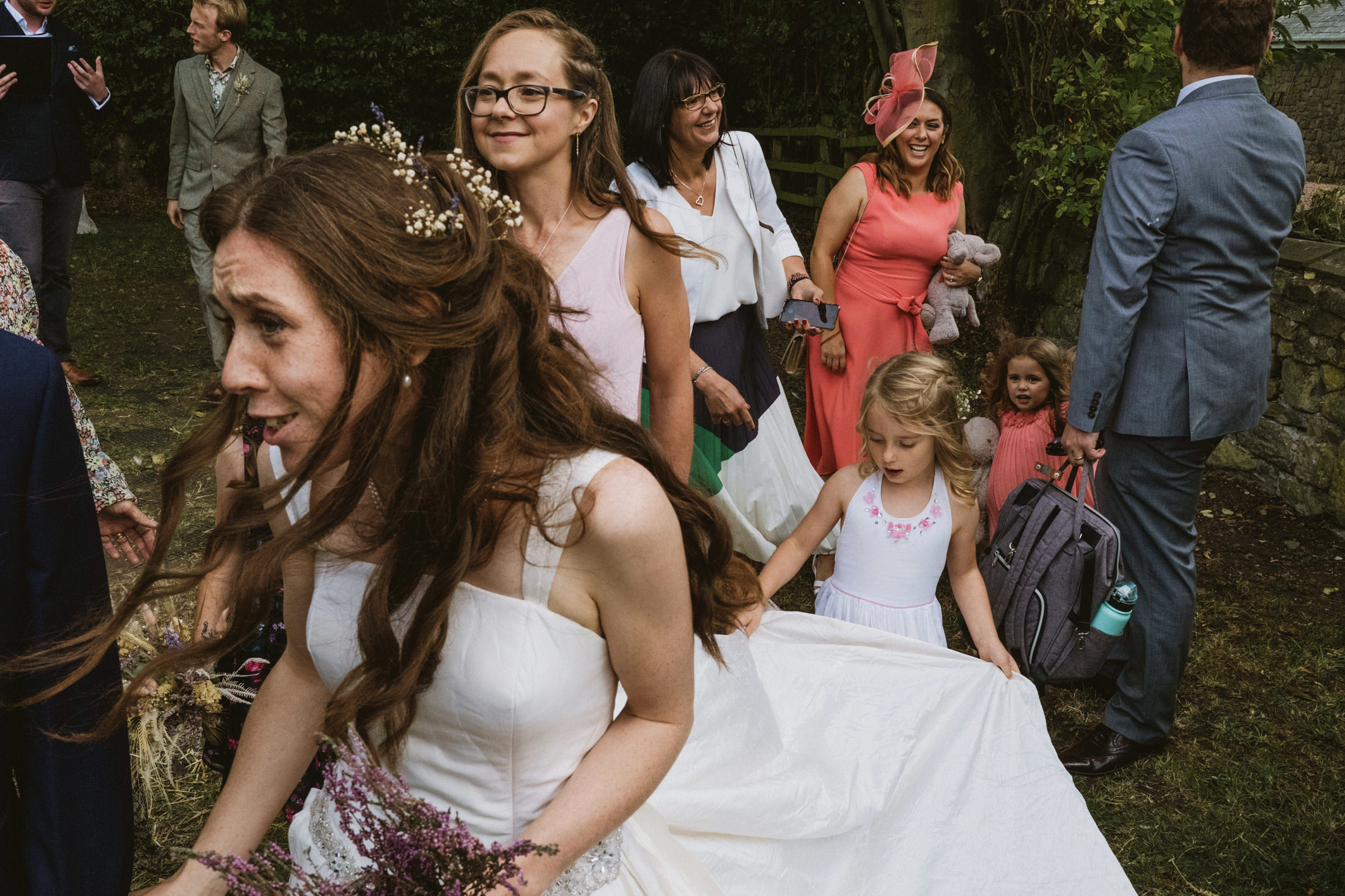 Bride walking with guests at outdoor wedding.
