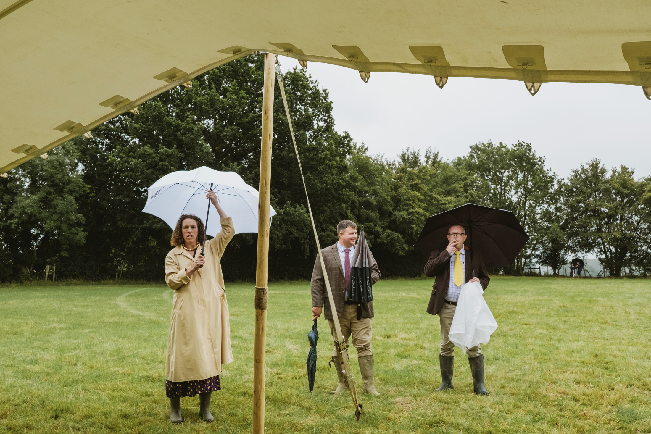 People with umbrellas at outdoor event.