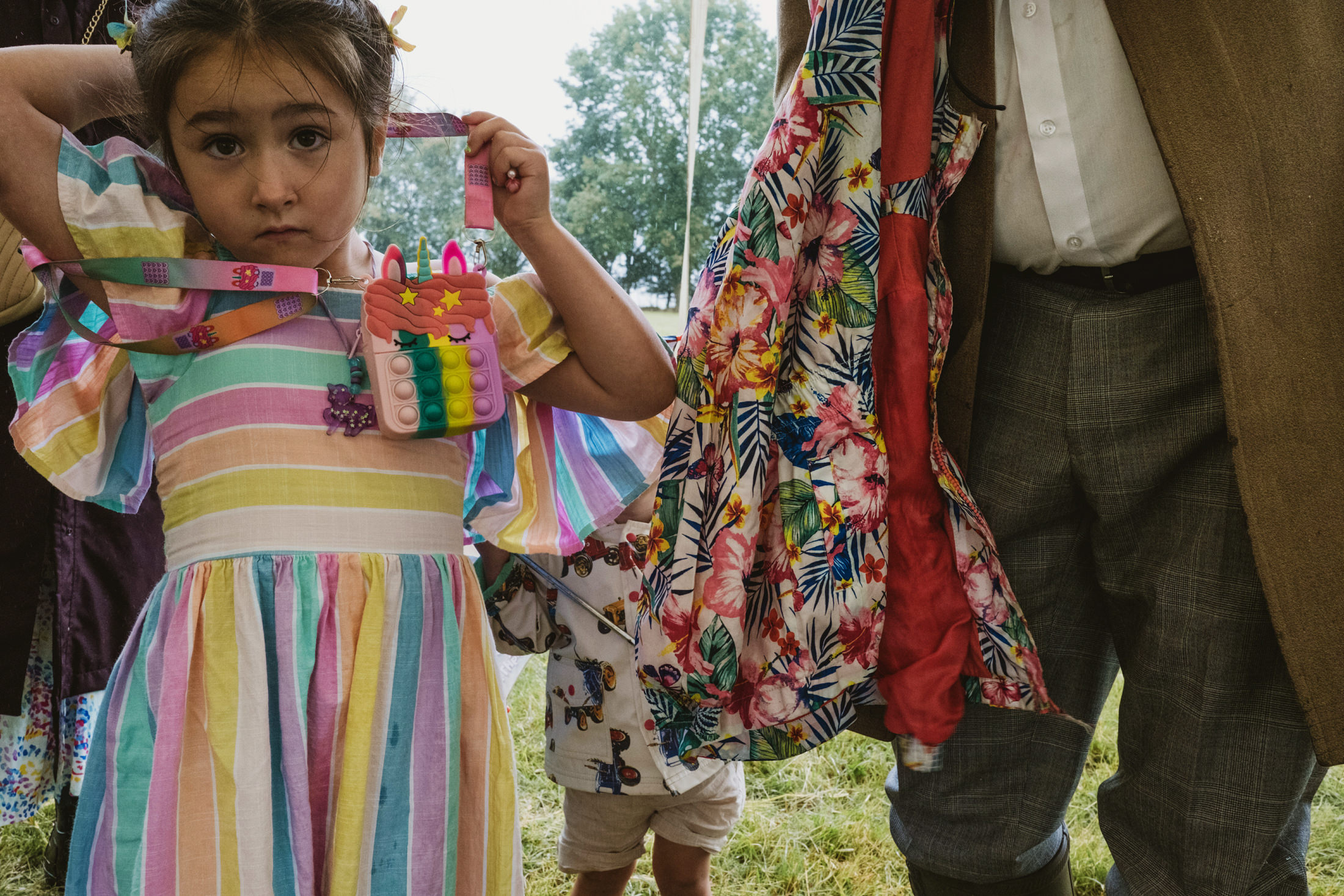 Child wearing stripe dress holds toy bag