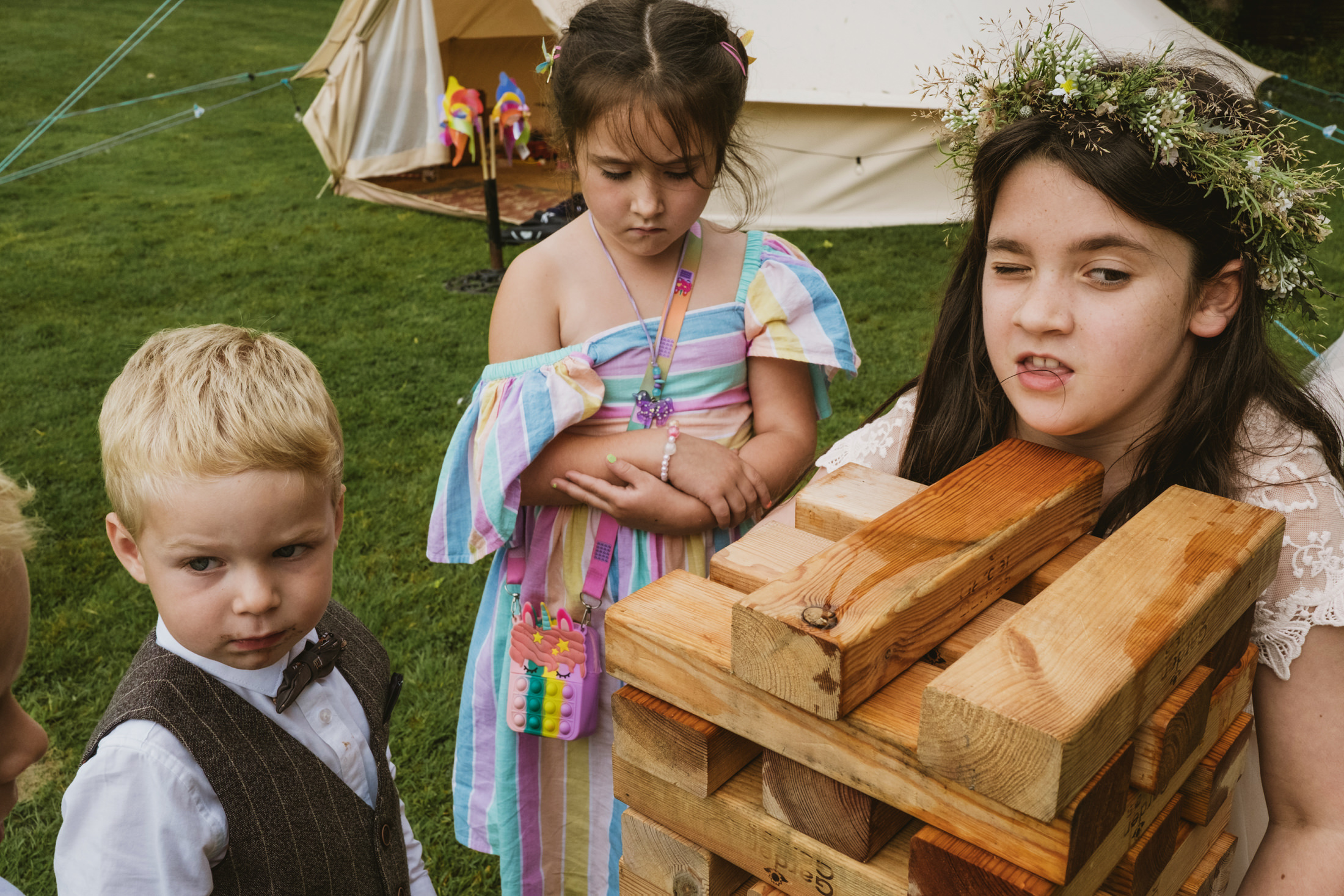 Children playing with wooden blocks outdoors.