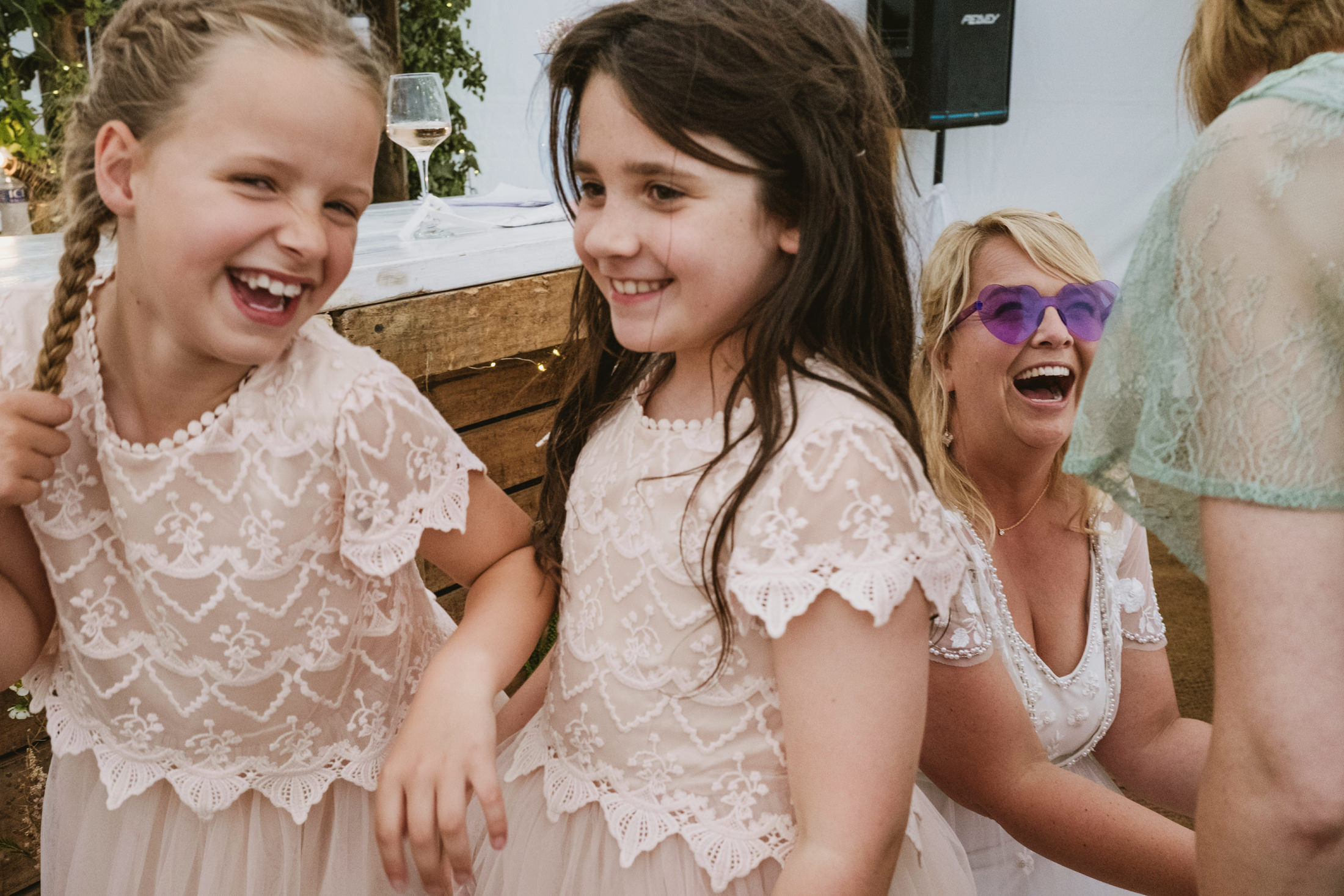Two girls and woman laughing at a wedding.