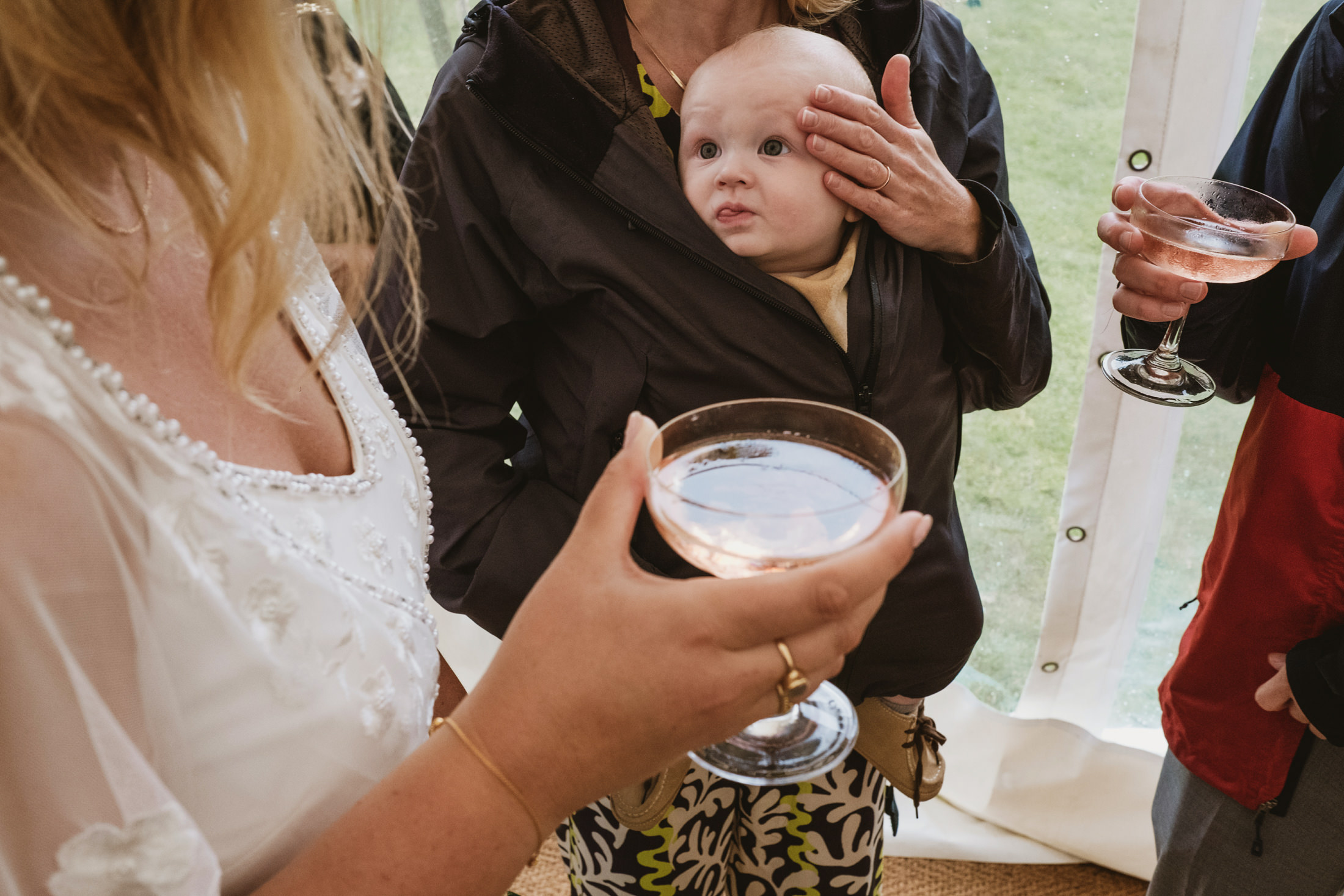 People at outdoor event with drinks and baby.