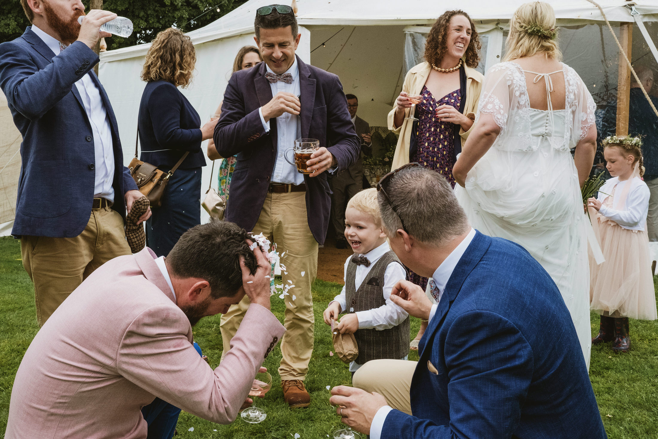 Wedding guests celebrate with laughter and confetti.