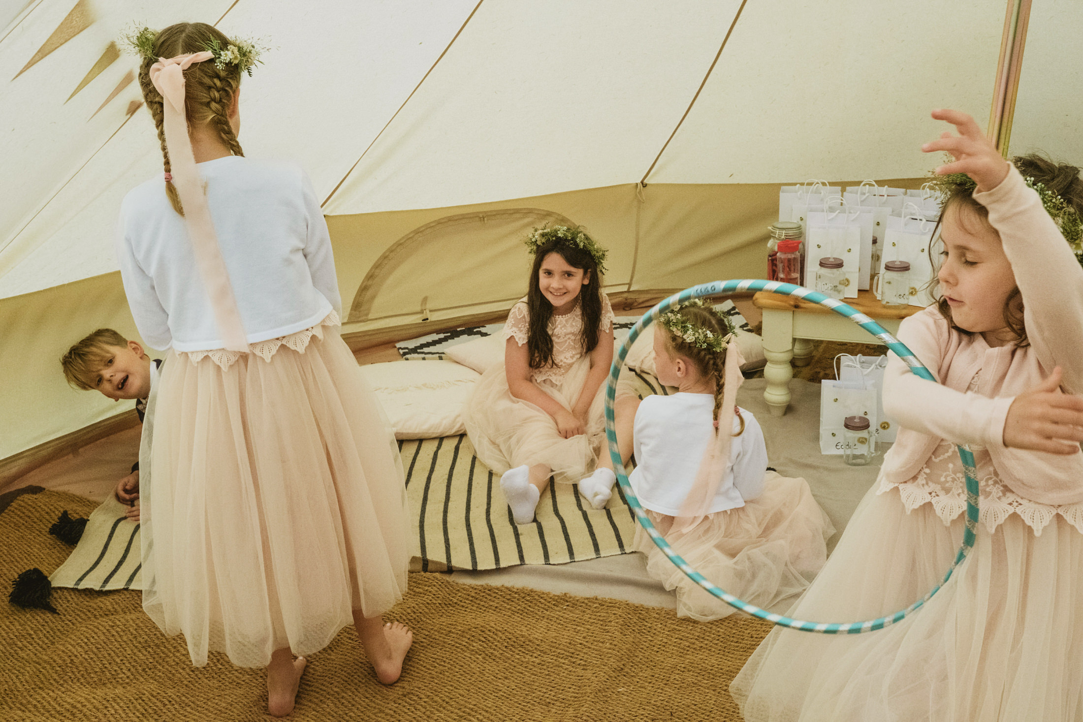 Children playing in a tent with hula hoop.