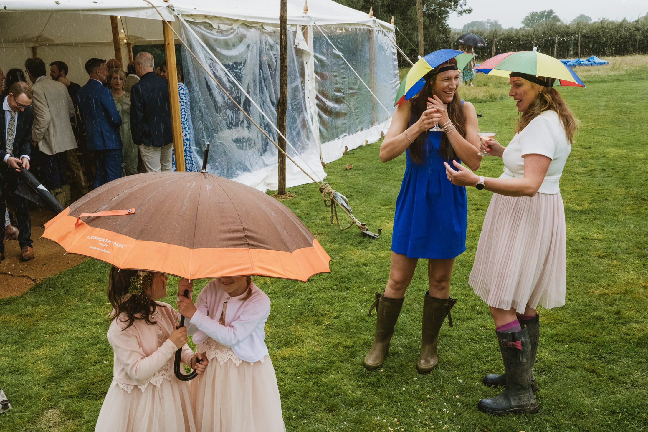 People enjoying outdoor event in rain with umbrellas.