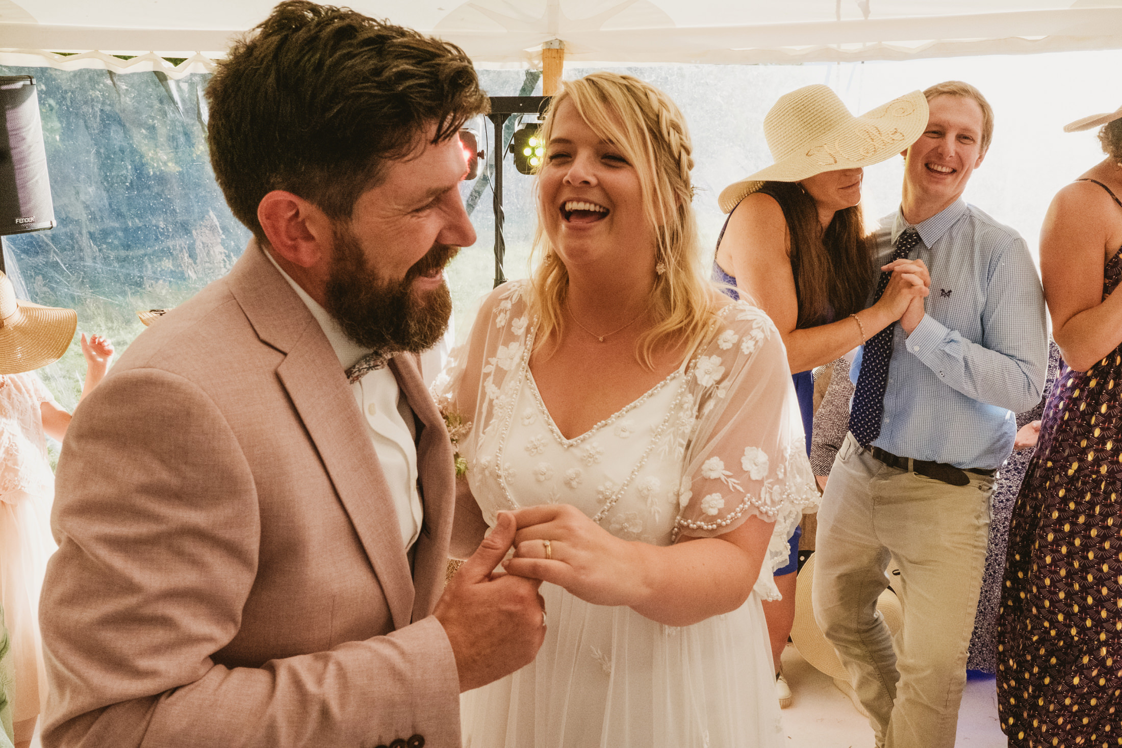 Bride and groom laughing at wedding reception.