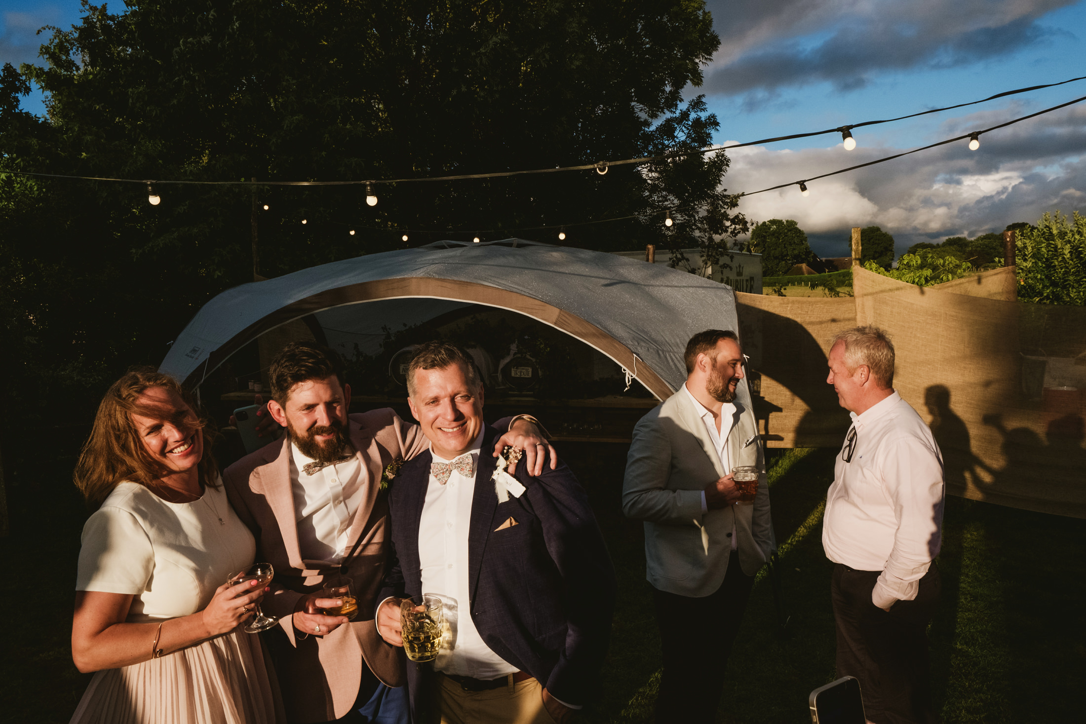 Group celebrating outdoors in evening sun.