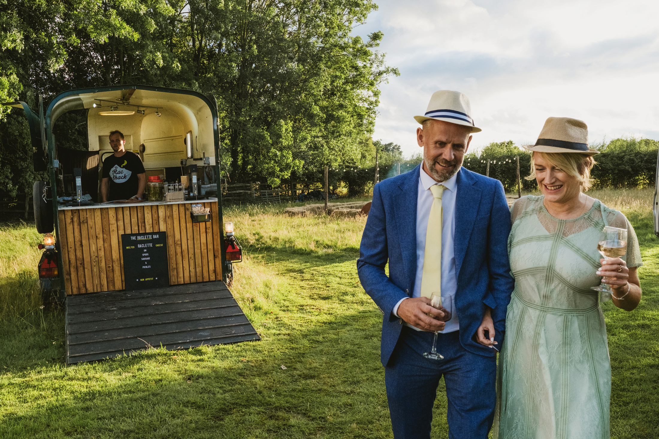 Couple in hats by mobile bar at outdoor event.
