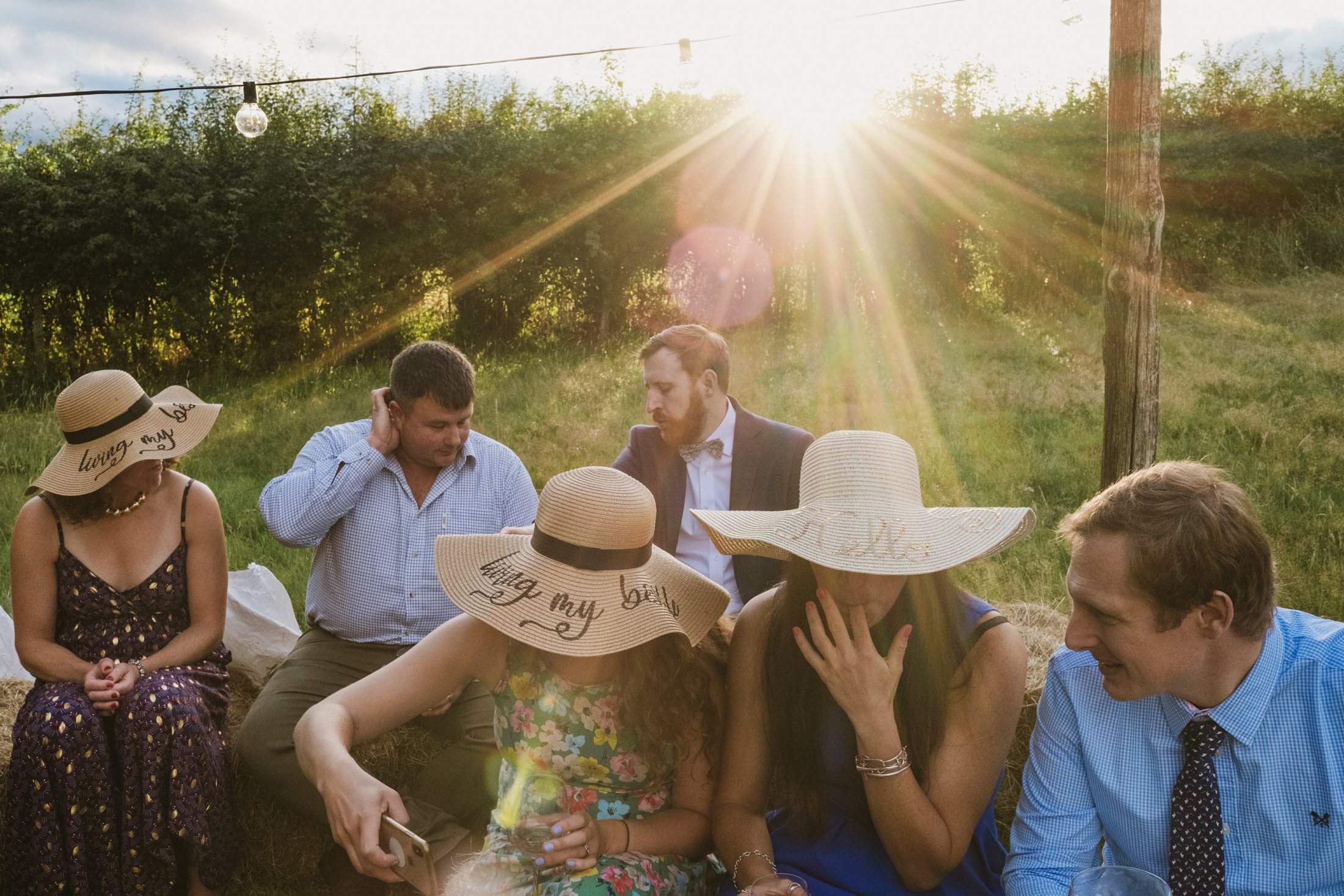 Group of people outdoors wearing sun hats, sunset