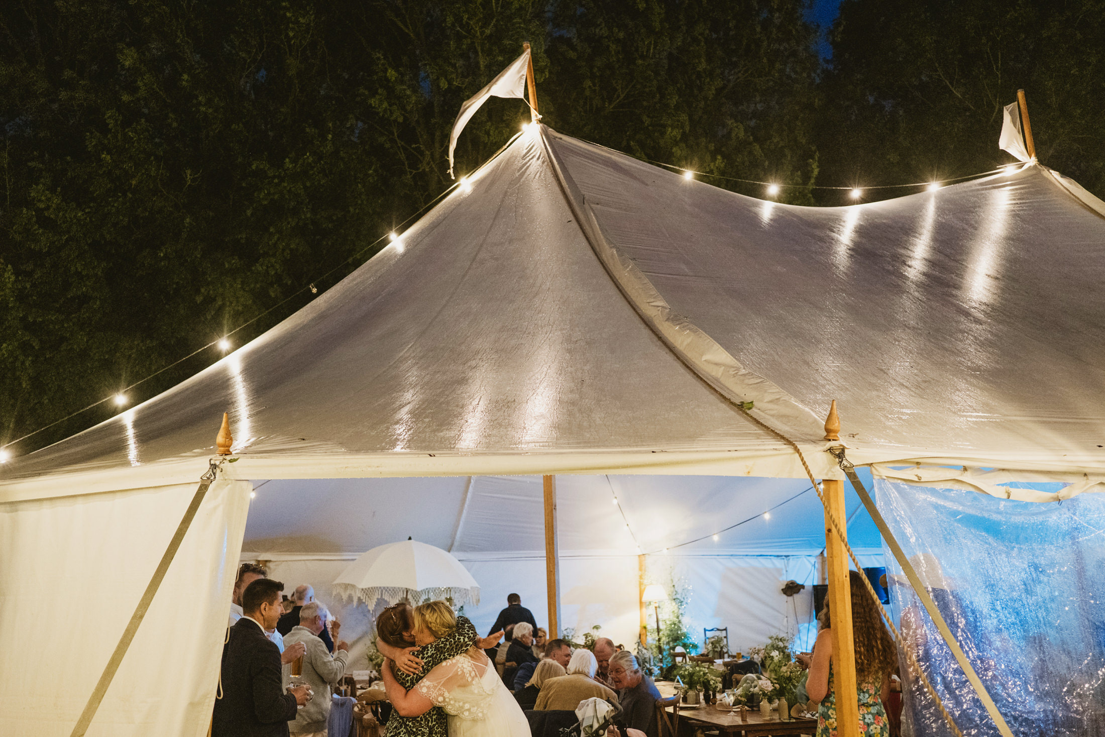 Wedding celebration inside a lit marquee tent