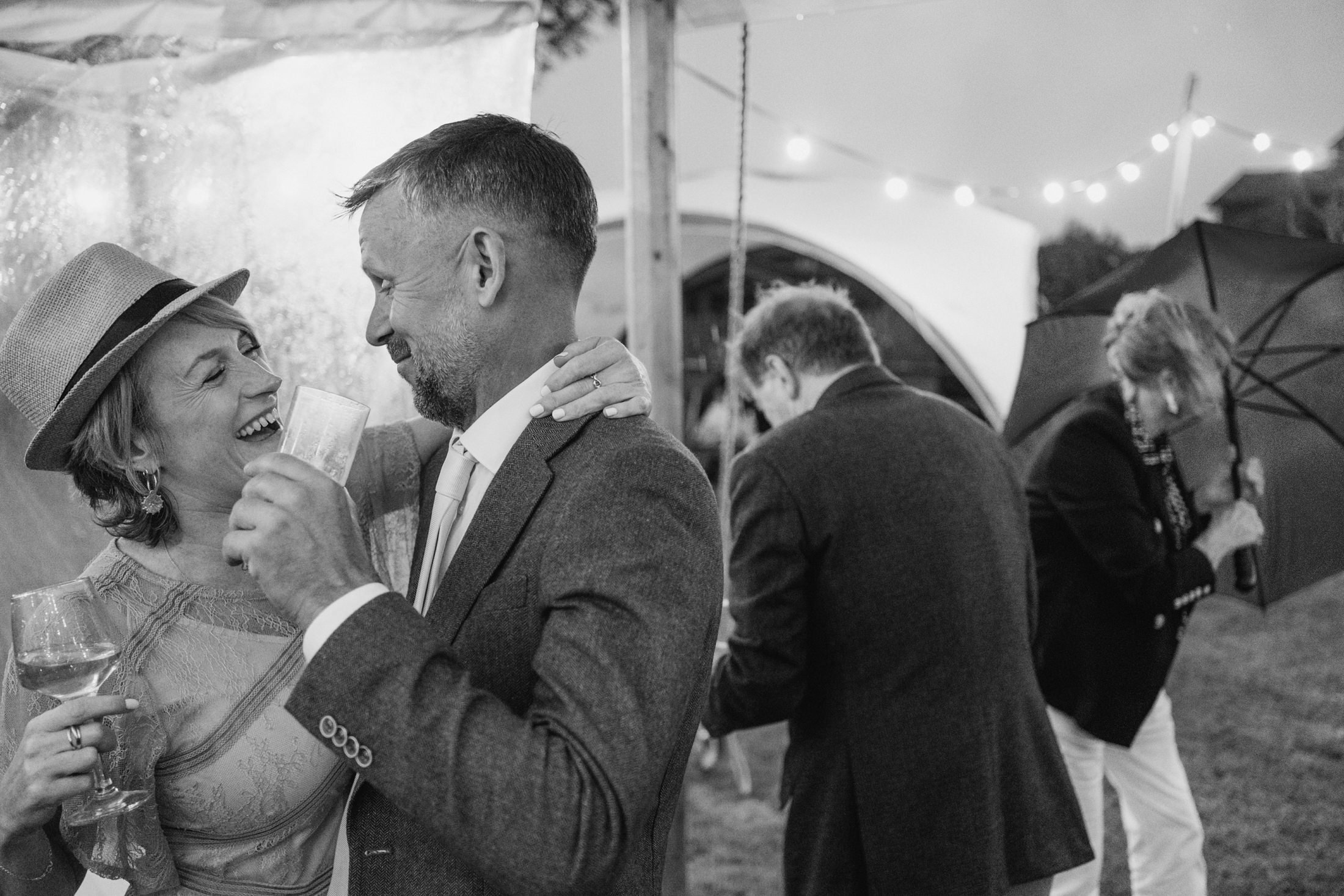 Smiling couple celebrate outdoors under lights.