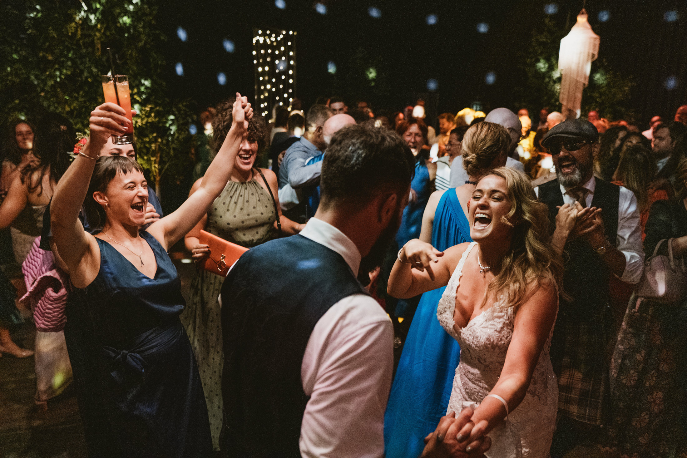 Guests celebrating at a lively wedding party. The tapestry of the photograph; anticipating the wild energy and vibrant human behaviour on a Denbighshire marquee dance floor.