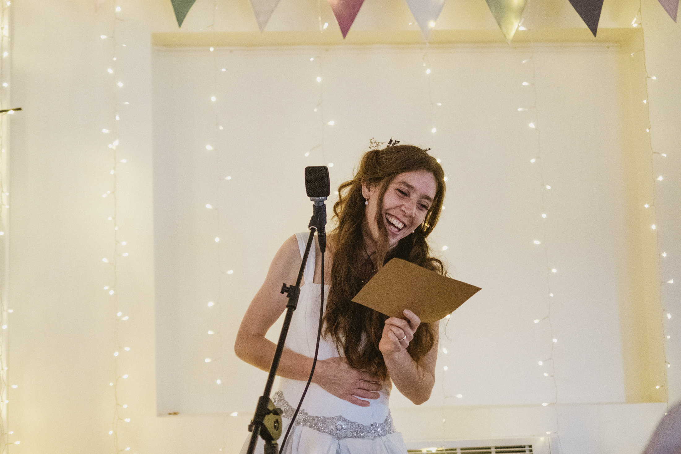 Woman laughing during a wedding speech.
