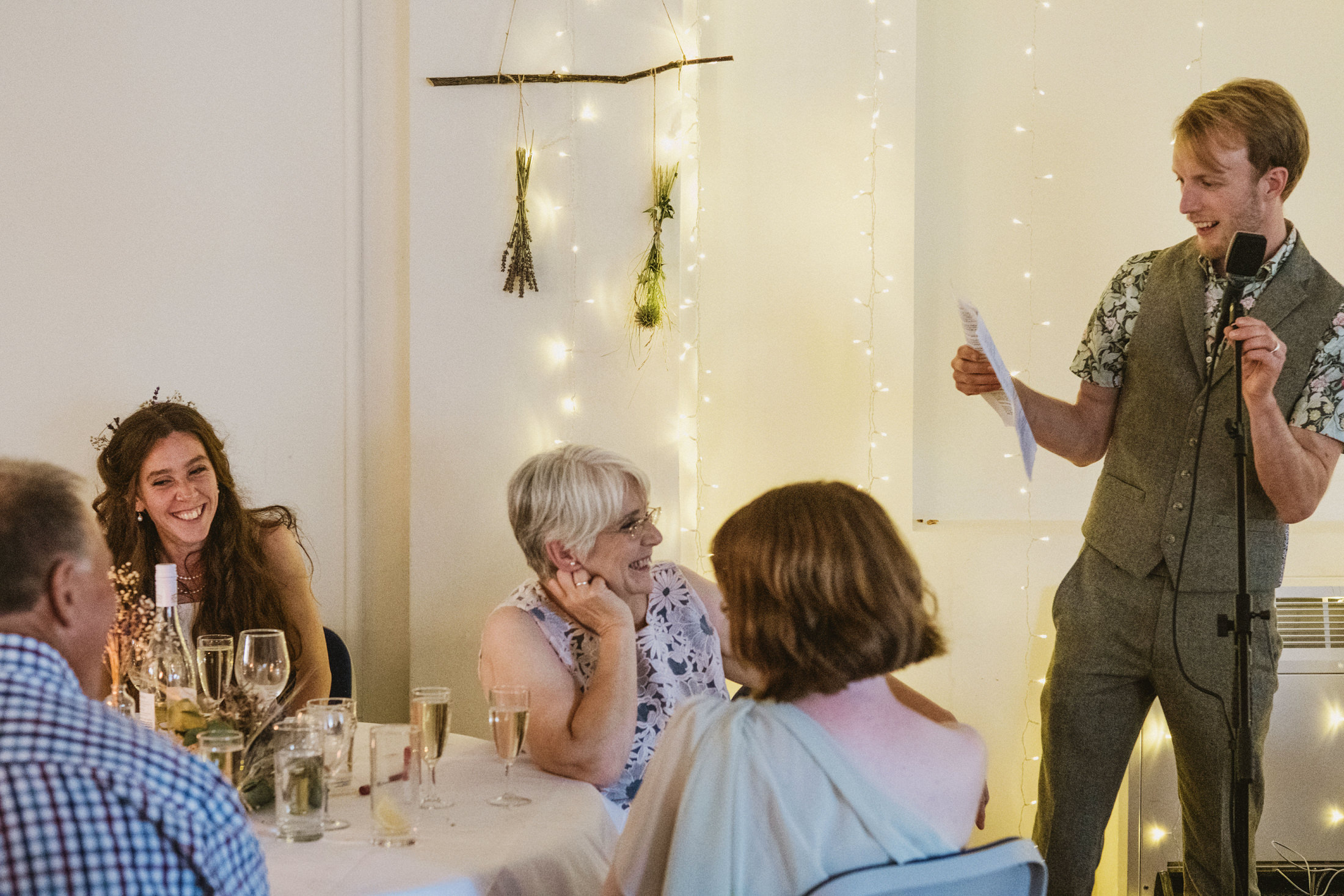 Man giving speech at wedding reception.