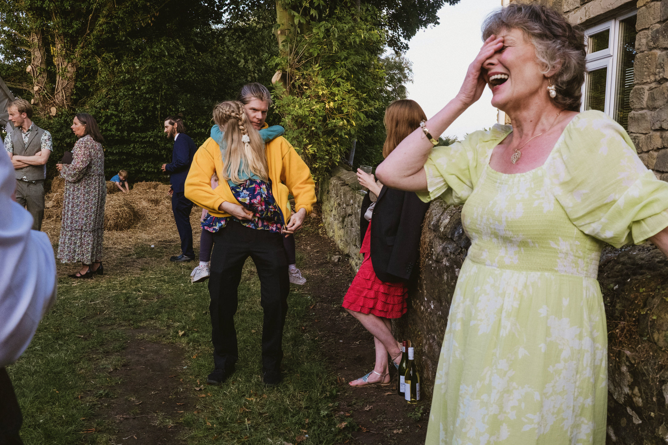 People laughing and talking at outdoor gathering.