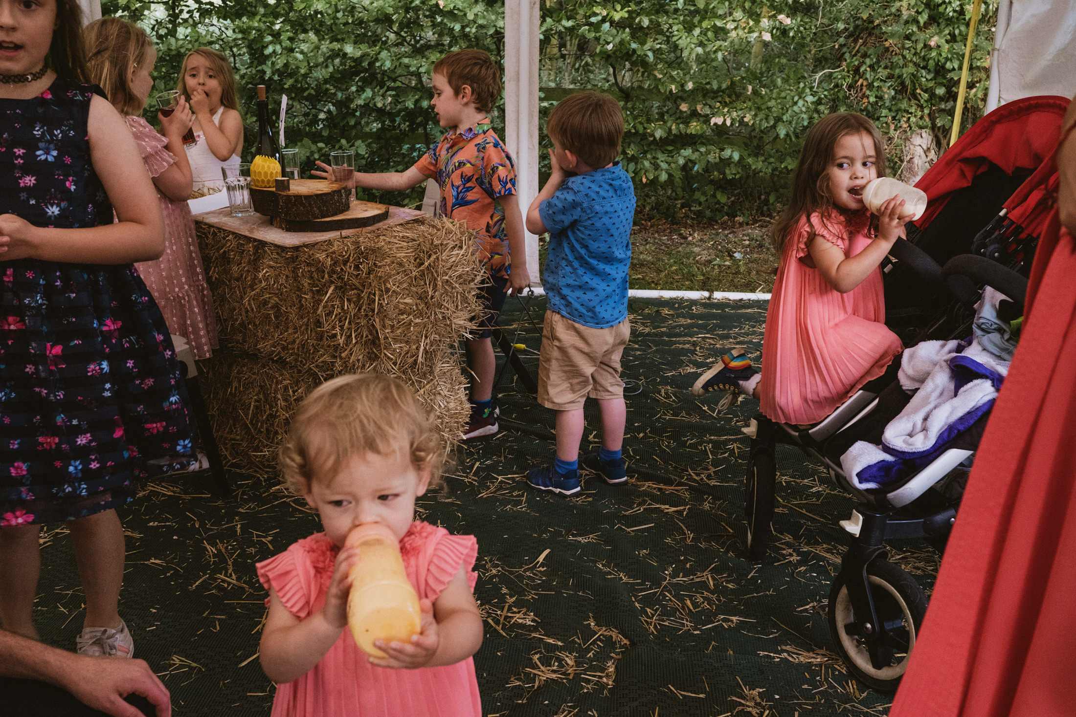Children enjoying drinks at an outdoor party.