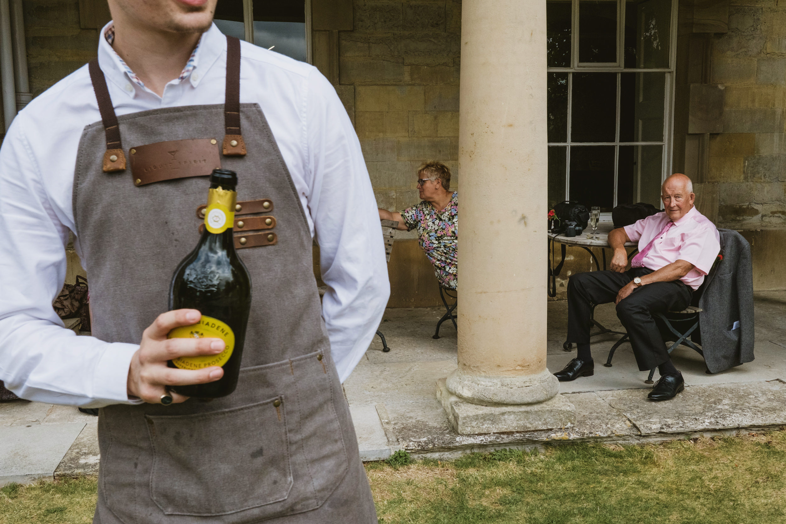 Waiter serving drinks to guests on patio