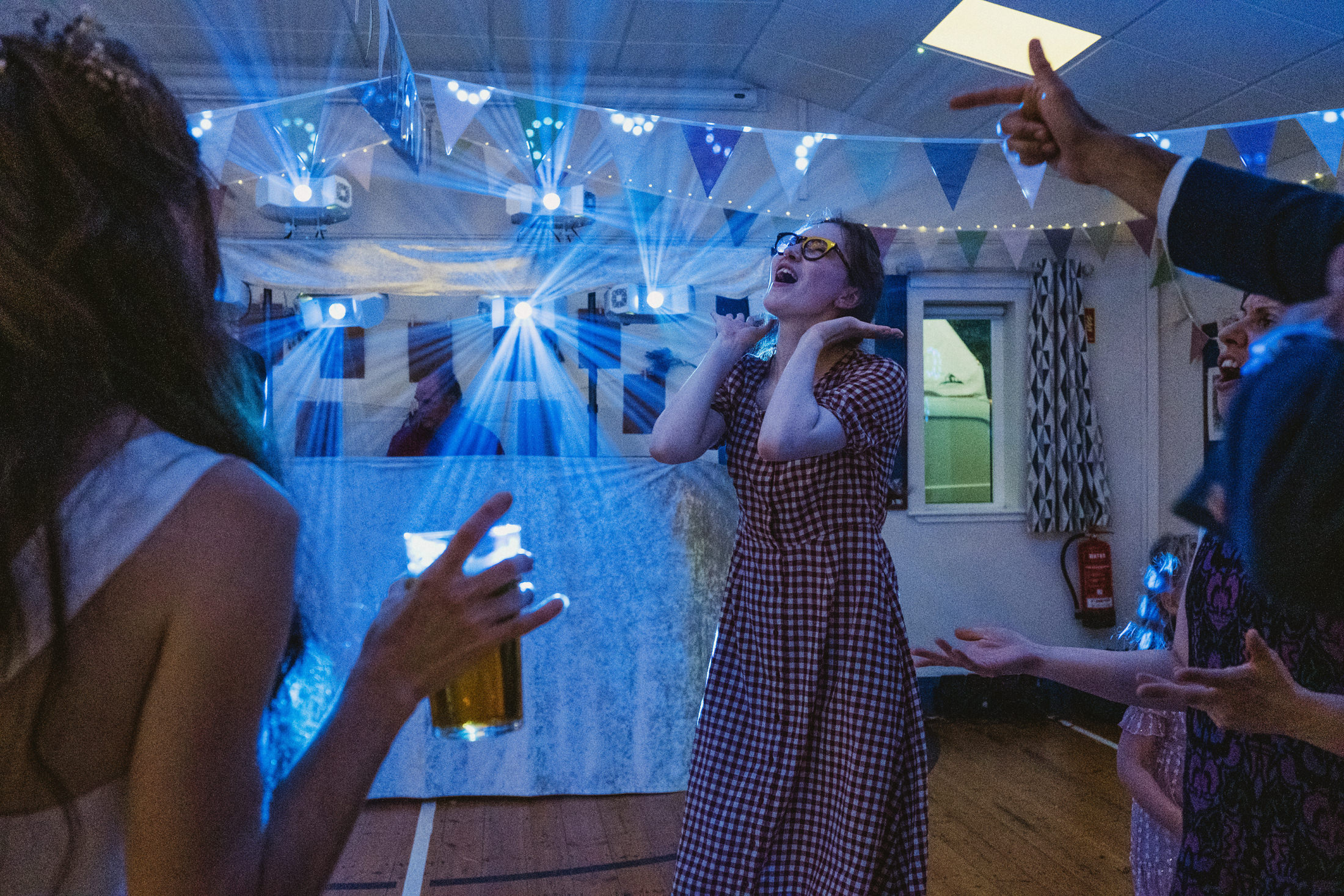 People dancing at a party with colourful lights.