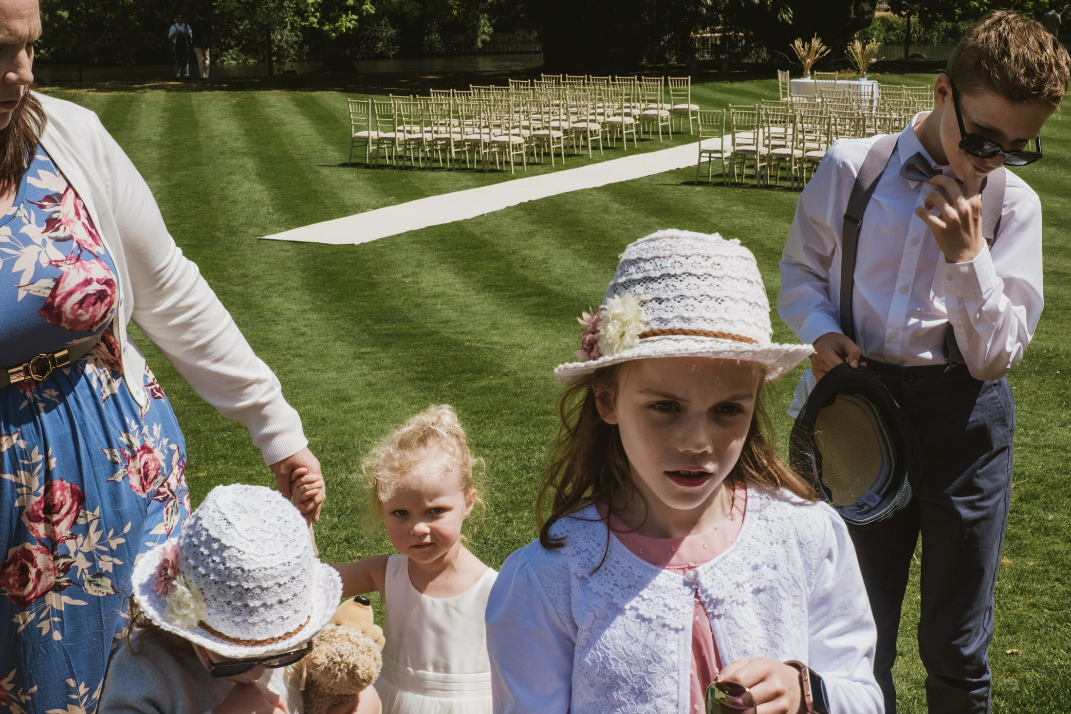 Children at outdoor wedding ceremony, dressed formally.