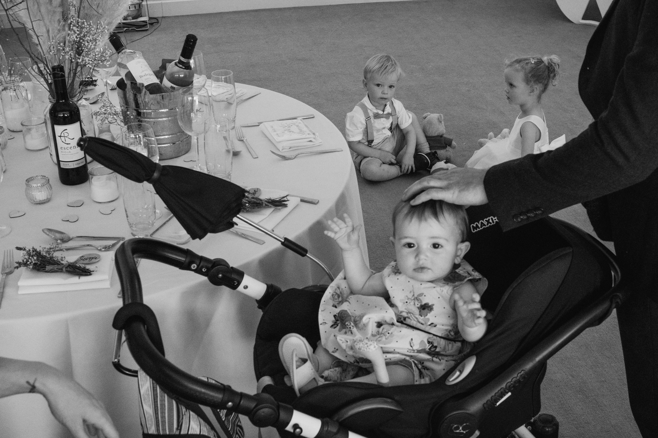 Children at a wedding reception with baby in pram.