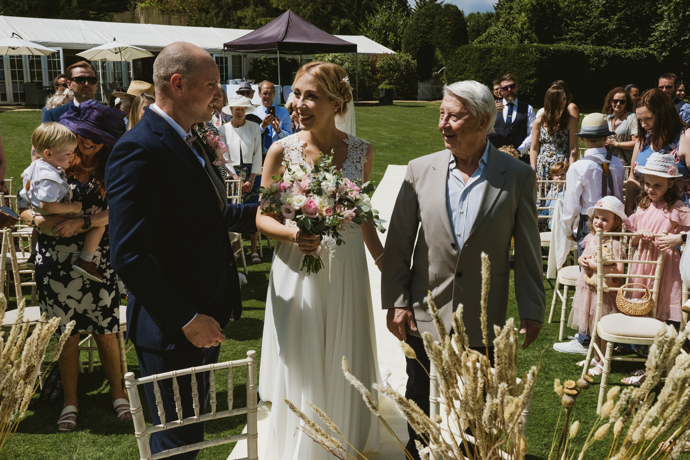 Bride walking down the aisle with family.