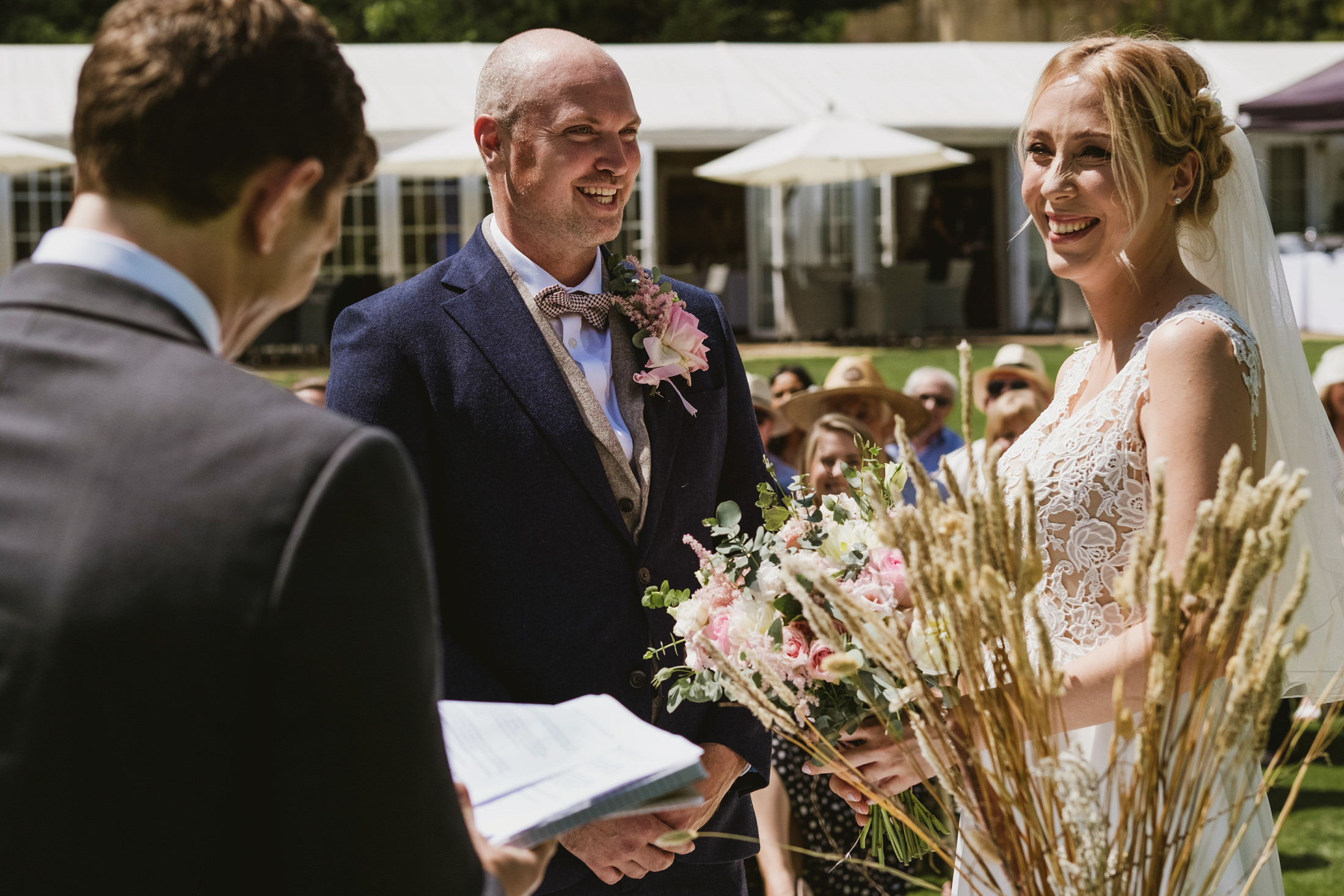 Outdoor wedding ceremony with happy couple smiling.