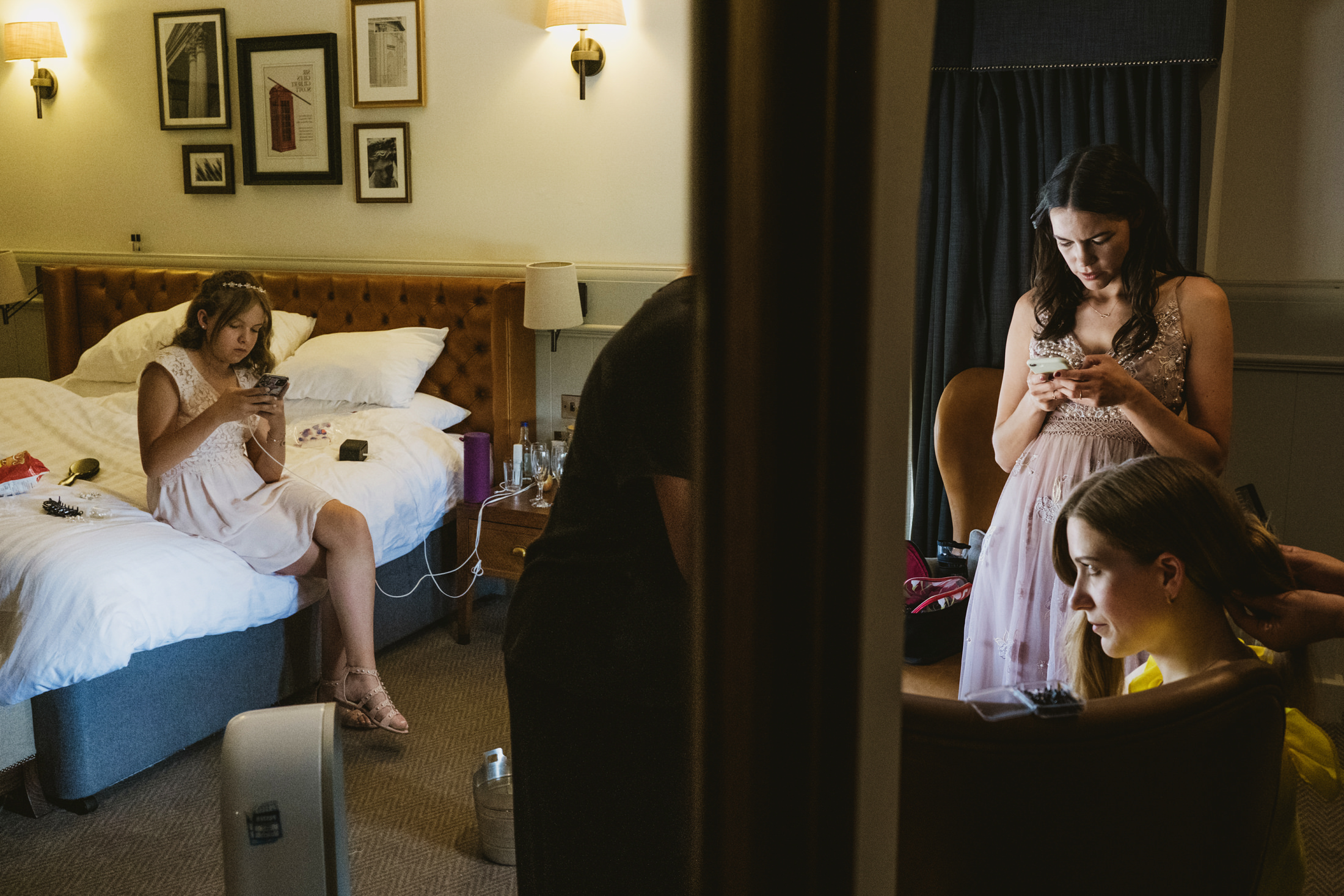 Women in dresses getting ready in a hotel room.