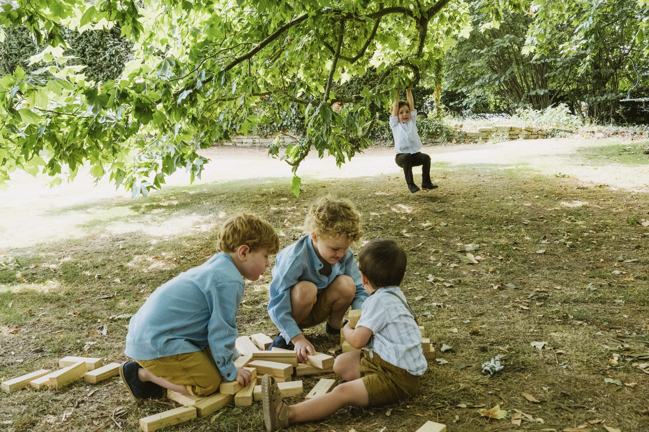 Children playing with blocks under a tree