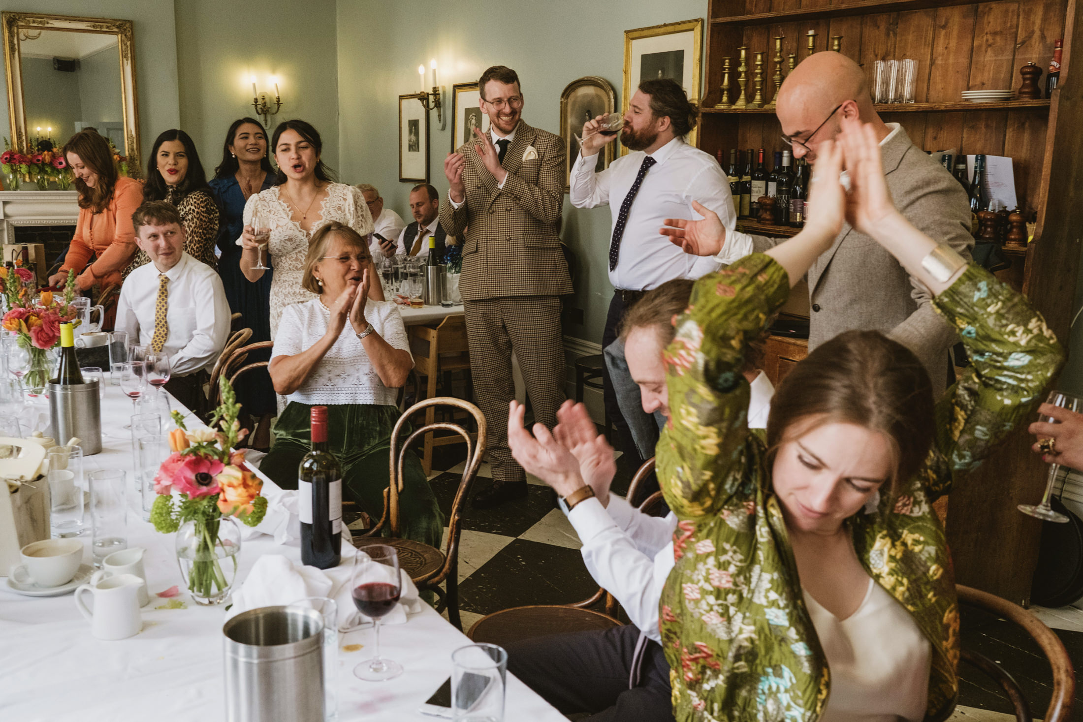 People celebrating at a party with wine and applause.