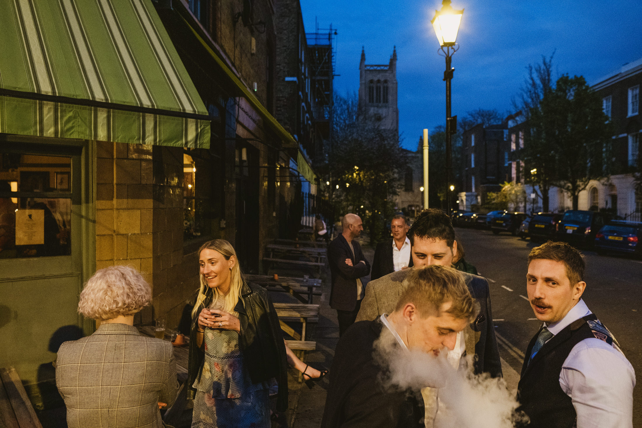 Group socialising outside a pub at night.