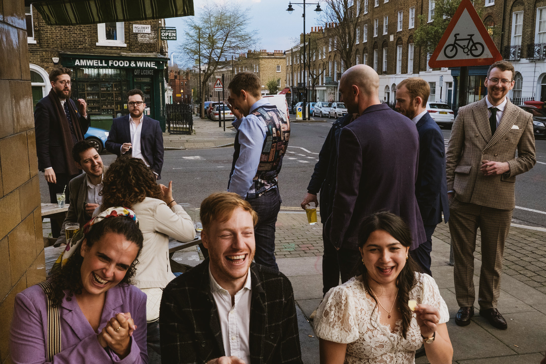 Group of people laughing outside a pub.