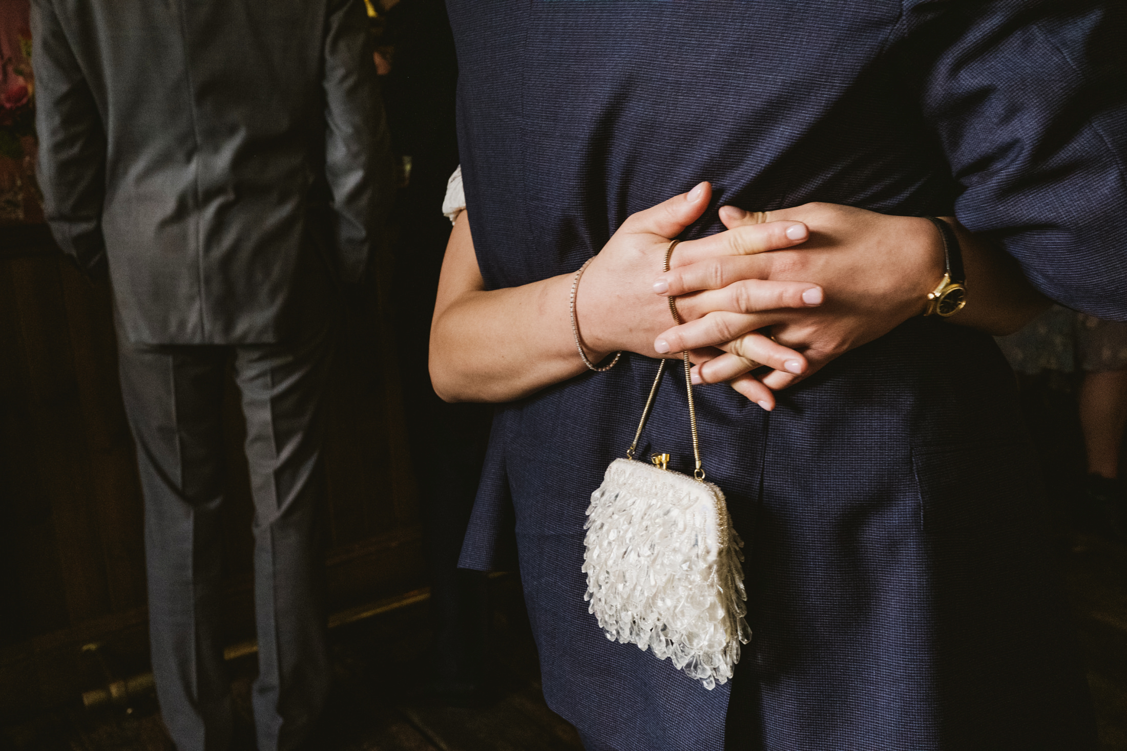 Couple hugging, woman holding beaded handbag.
