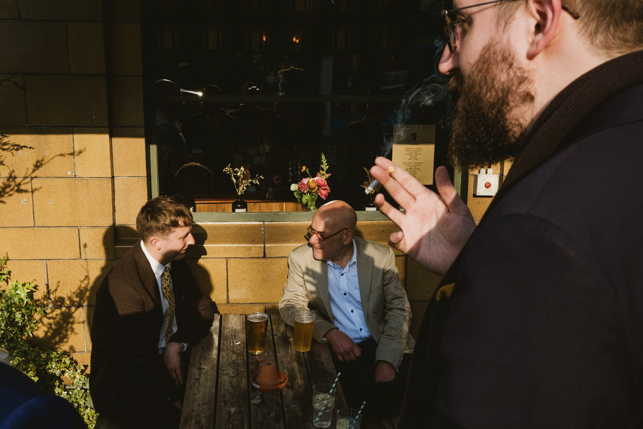 People socialising outside with drinks and cigarette