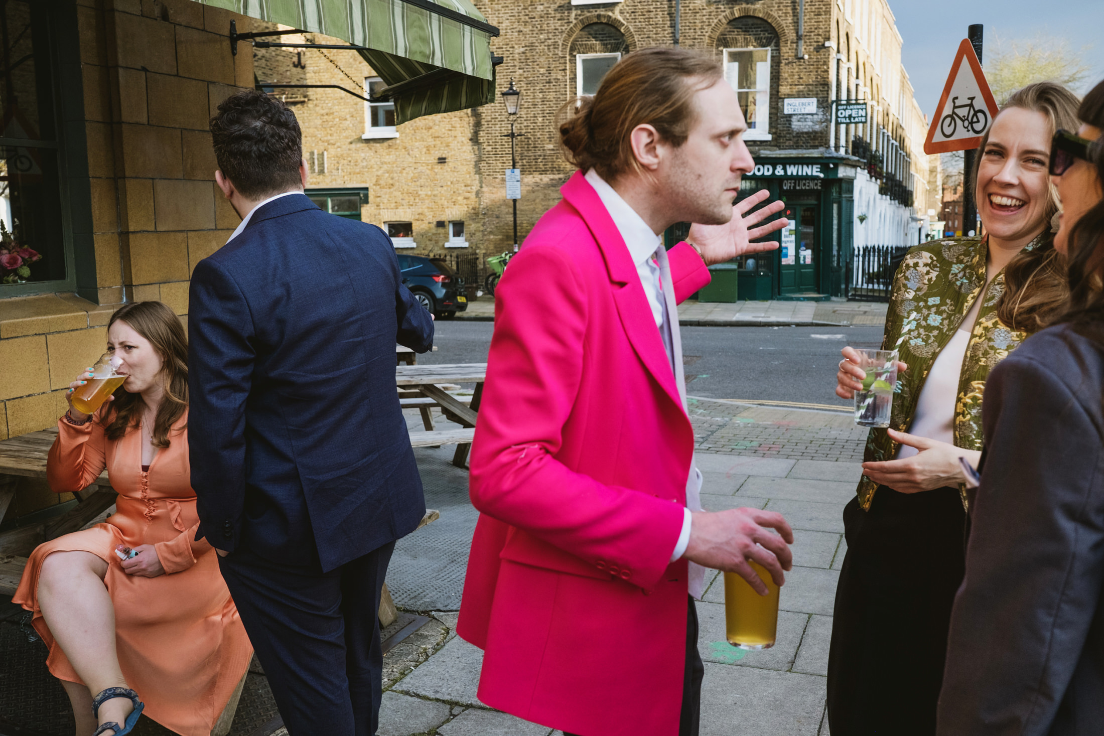 People socialising with drinks outside a pub.