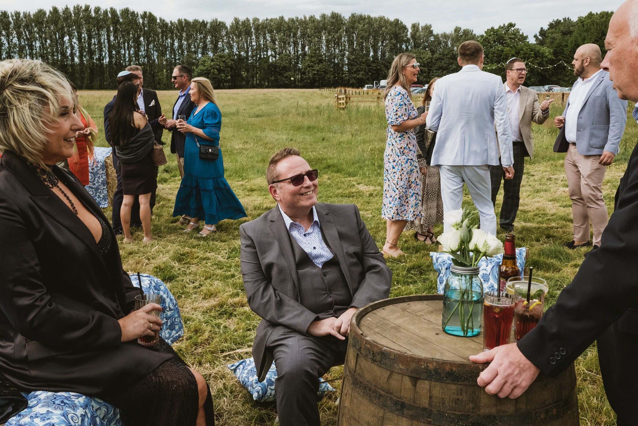 Outdoor gathering with people socialising in a field.