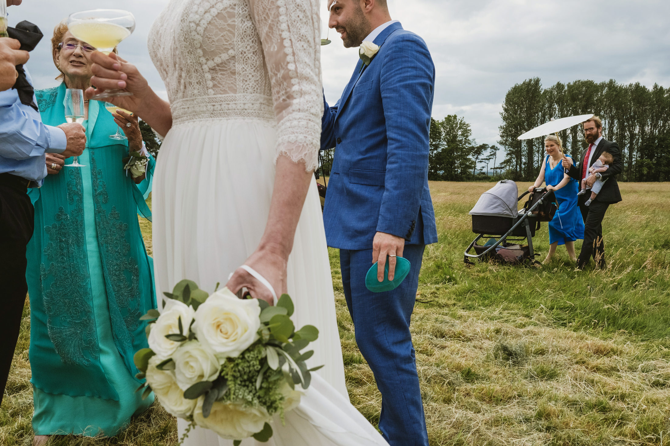Wedding guests socialising outdoors with drinks.