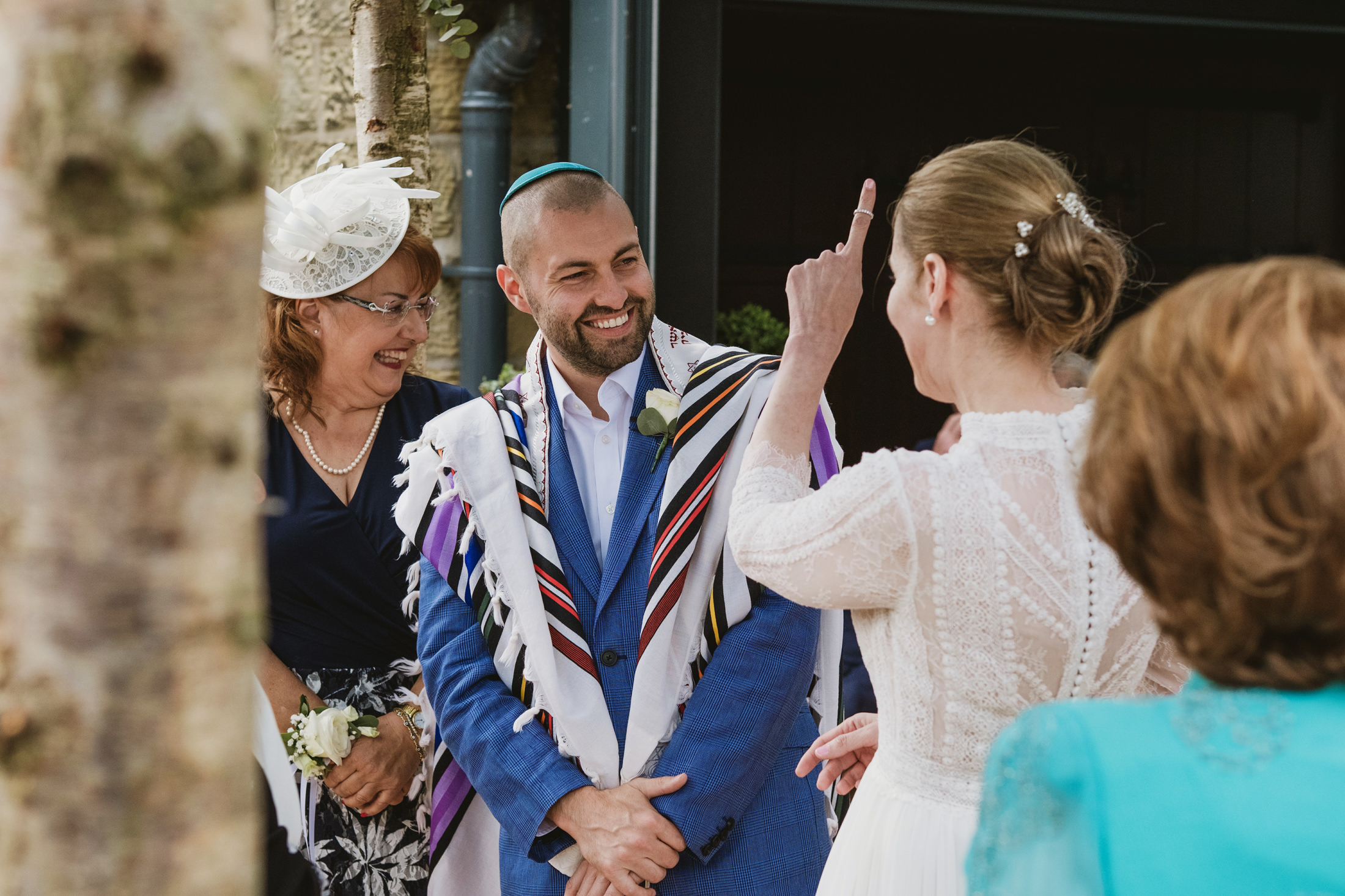 Smiling people at a wedding celebration outdoors.