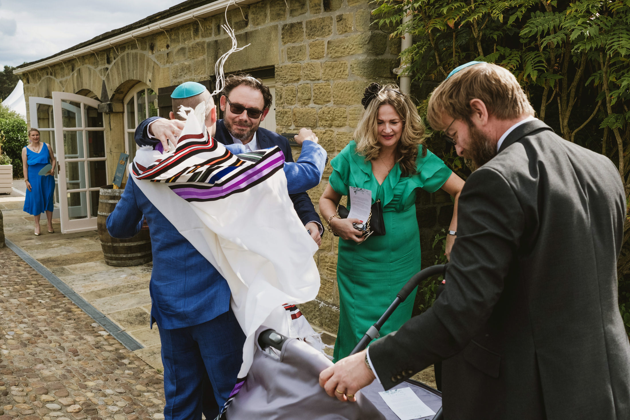 People celebrating outdoors with colourful shawl.